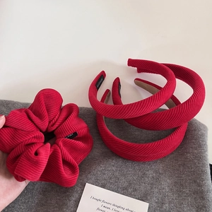 Détail d'un ensemble serre-tête et chouchou en velours côtelé rouge à texture côtelée