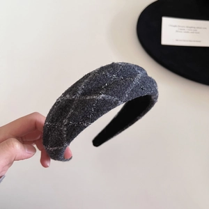 Close-up of thick dark grey plaid tweed headband with textured wool fabric detail