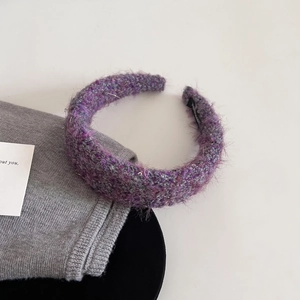Close-up of a wide purple knit headband with sparkling sequins and fluffy wool texture