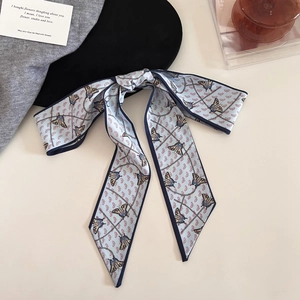 Light blue paisley silk ribbon with butterfly print tied in a bow on a stylish background