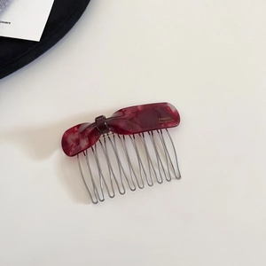 Detail of red marble acetate bow hair comb with gold France Handmade text and silver teeth