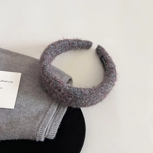 Detail of a purple and gray tweed headband with fuzzy texture and handmade label