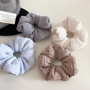 Set of 4 cable knit scrunchies in blue, grey, beige, and khaki with woven label detail