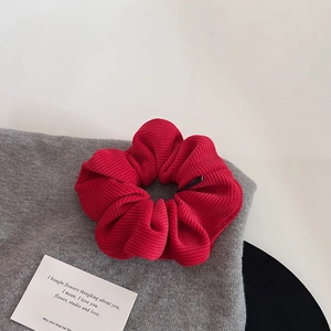 Chouchou élégant en velours côtelé rouge avec texture nervurée sur tissu doux premium