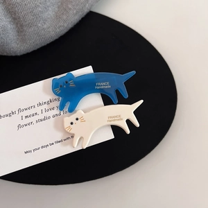 Détail des barrettes chat faites à la main en acétate, coloris bleu et blanc