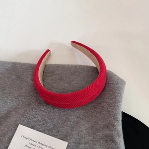 Gros plan sur le serre-tête en velours côtelé rouge montrant la texture et la doublure beige