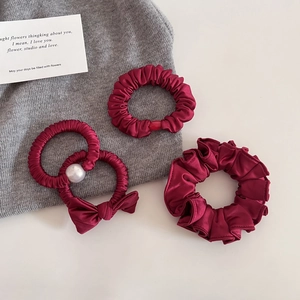 Ensemble de trois chouchous en satin bordeaux avec perles et détails de nœuds élégants