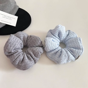 Macro detail of knit texture on blue and grey scrunchies with soft padded fabric