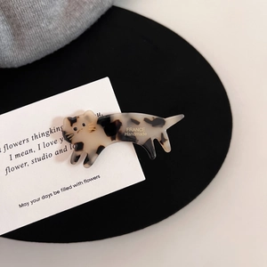 Vue détaillée d'une pince à cheveux chat en acétate avec texture ambre et dorures