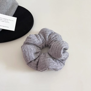 Close-up of light grey ribbed knit scrunchie with soft pleated texture for women