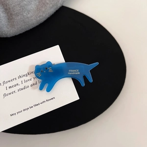 Détail d'une pince à cheveux chat en acétate bleu avec logo France Handmade doré gravé