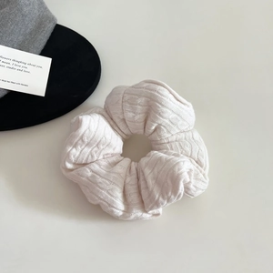 Detail of soft pink knitted scrunchie with rib texture for elegant hairstyles