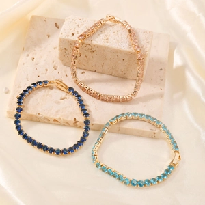 Elegant gold tennis bracelets with navy, light blue, and champagne round-cut gemstones