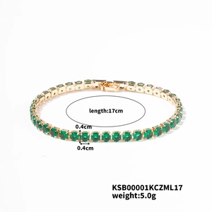 Macro detail of a 17cm gold tennis bracelet with 0.4cm green round-cut gemstones