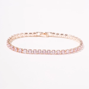 Close-up van roségouden tennisarmband met ronde roze zirkonia kristallen en veilige sluiting