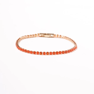 Close-up van een gouden tennisarmband met oranje zirkonia en veilige sluiting