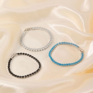 Luxurious tennis bracelets with black, turquoise, and white stones on silk fabric