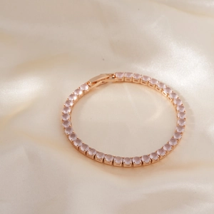 Luxurious rose gold tennis bracelet with pink cubic zirconia on champagne silk fabric