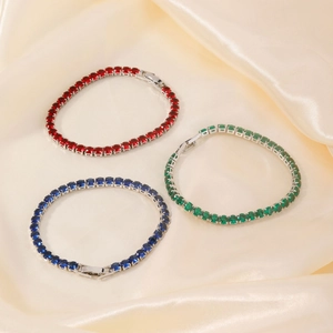 Hip hop tennis bracelets with red, blue and green oval gemstones on silk background