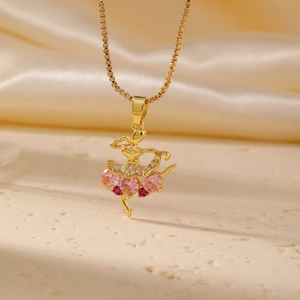 Collana con ciondolo ballerina in oro e pietre rosa su elegante sfondo di seta
