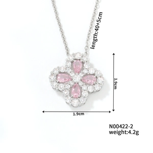 Macro view of silver clover necklace featuring pink teardrop gems and zircon pavé inlay