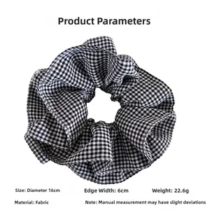 Detail view of large 16cm black and white checkered fabric hair scrunchie with soft pleats