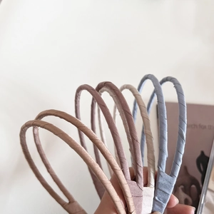 Serre-têtes fins en satin aux couleurs Morandi présentés sur un fond esthétique beige