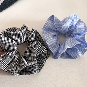Detailed macro view of retro plaid gingham scrunchies in black and blue fabric