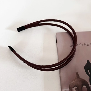 Gros plan d'un serre-tête en satin marron à double couche avec embouts de protection