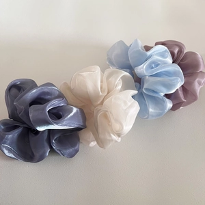 Macro detail of large organza hair scrunchies showing sheer texture and pearly luster