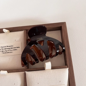 Vue détaillée d'une pince à cheveux en résine ambrée avec texte doré France Handmade