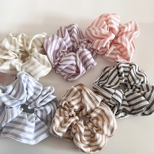 Detailed view of six colorful striped scrunchies in pastel shades and soft fabric