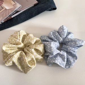 Close-up of yellow and blue floral scrunchies with white flowers on denim background