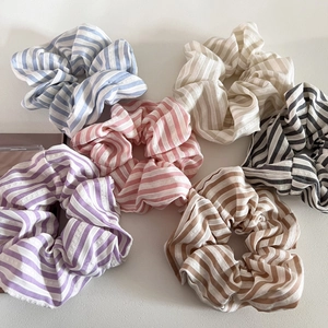 Set of six colorful striped scrunchies in blue, pink, and pastel tones for hair styling