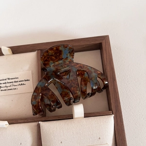 Gros plan sur la pince à cheveux en acétate écaille avec logo France Handmade doré