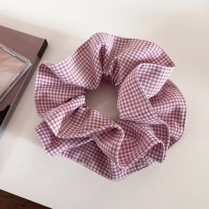 Close-up of pink and white gingham oversized scrunchie with soft cotton pleats texture