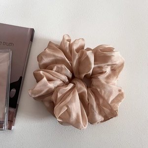 Close-up of fluffy champagne mesh scrunchie with soft sheen and natural folds