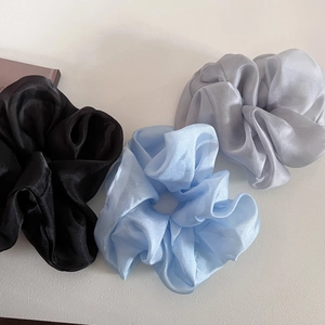 Oversized satin scrunchies in black, light blue, and silver gray with pearl sheen texture