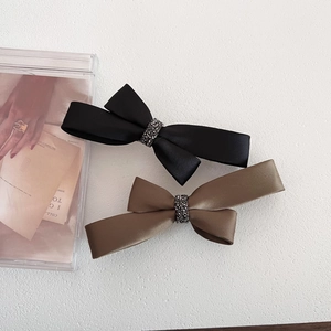 Luxurious satin bow hair clips in black and khaki with sparkling rhinestone details