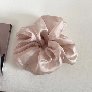 Detailed close-up of large champagne pearl tulle scrunchie with elegant silk pleated texture