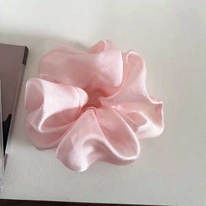 Detail of soft pink large organza scrunchie with shimmering texture and elegant pleats