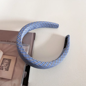 Nahaufnahme eines gepolsterten karierten Haarreifens in Blau und Weiß auf Vintage-Hintergrund