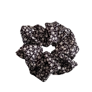 Black floral scrunchie with white flower patterns and elastic fabric for women