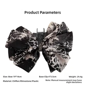Detail view of ink print chiffon bow hair claw with dimensions 19x14cm and rhinestone