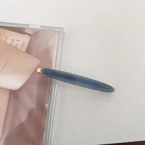 Close-up of Morandi blue acetate hair clip featuring gold Barrette La France lettering
