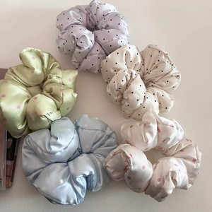 Flat lay of five colorful satin polka dot scrunchies in lavender green and blue