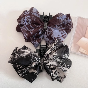 Close-up of leopard print chiffon bow hair claws with sparkling silver rhinestones