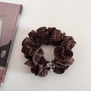 Close-up of deep brown pleated hair scrunchie with sparkling crystal bead detail