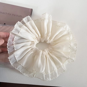 Detailed macro view of white layered mesh scrunchie with delicate sheer fabric textures