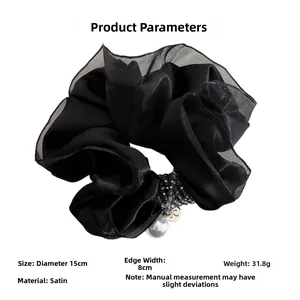 Dettaglio scrunchie in raso nero con perline e ciondolo a perla, diametro di circa 15 cm